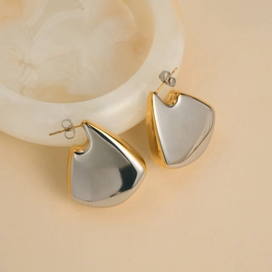 Macro detail of high-polish two-tone fan-shaped earrings in gold and silver finish