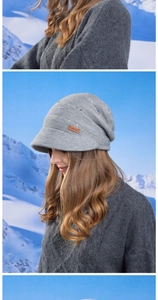 Close-up of grey knitted beanie with brim and brown leather label in winter setting