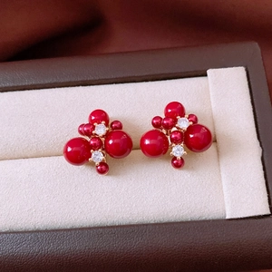 Detailed macro view of 18K gold plated red bead earrings with clear zircon accents