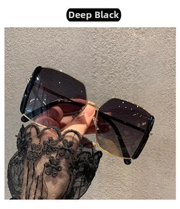 Detail of oversized Ink Black sunglasses with gradient lenses and gold rivet accents