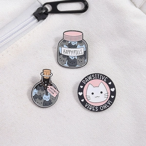 Cartoon cat enamel pins set on white canvas bag with heart bottle and round kitty badges