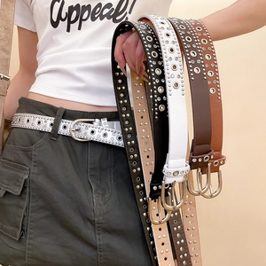 Close-up of Y2K style leather belts with metal eyelets and sparkling rhinestones