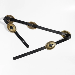 Close-up of black leather belt featuring antique bronze oval buckles with geometric patterns