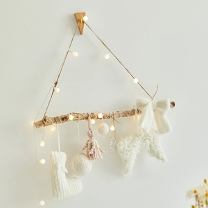 Nordic Christmas wall hanging with wood branches, LED lights and white knit ornaments