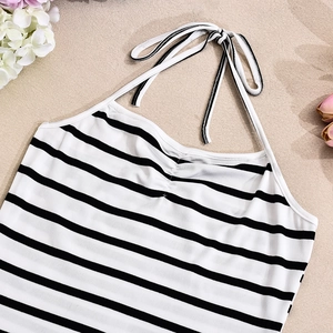 Dettaglio del crop top in maglia a righe bianche e nere con lacci al collo all'americana