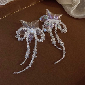 Detail view of aurora flower tassel earrings with iridescent petals and clear beads
