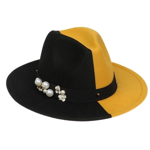 Detail of two-tone fedora hat with pearls, metal studs and white floral ribbon trim