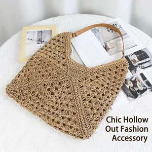 Hollow straw shoulder bag with leather strap on a rustic table for summer vacation