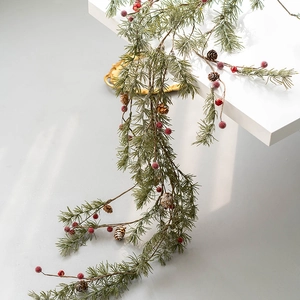 Nordic pine needle garland with red berries and pinecones on a white staircase