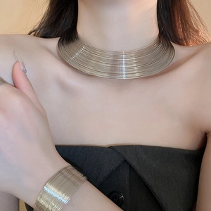 Detail of multi-layer gold wire wrap necklace and bracelet set on a female model