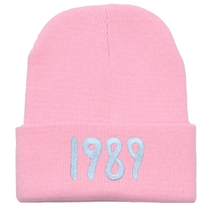 Pink Taylor 1989 embroidered knit beanie with light blue lettering on white background