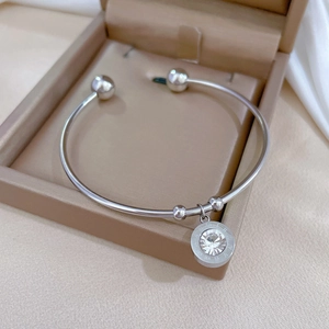 Detail of silver titanium steel bracelet with roman numeral ring pendant in a gift box
