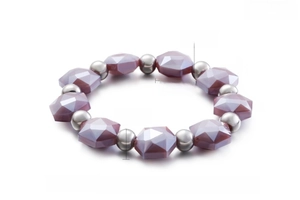Detail of faceted purple crystal beads and smooth stainless steel spheres on a beaded bracelet