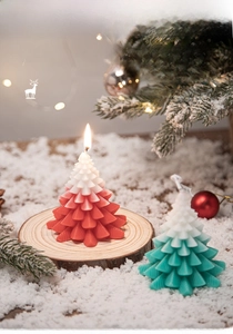 Detailed view of Christmas tree scented candles with snow-covered pine branch background
