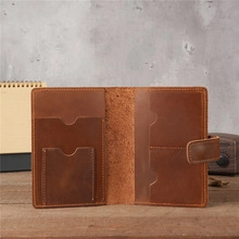 Internal view of brown leather bag showing card slots and compartments on a wooden desk