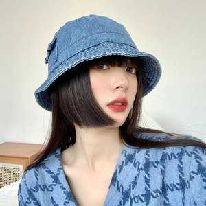 Detail of blue denim bucket hat showing washed texture and premium stitching