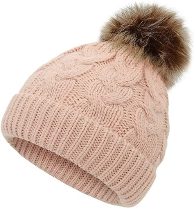 Close-up of pink cable-knit beanie texture and soft faux fur pom-pom detail