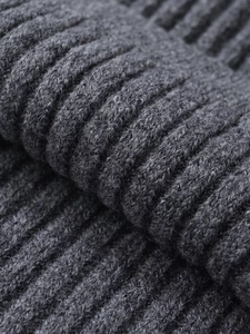 Close-up of dark grey thick ribbed knit texture with detailed yarn fibers for warmth