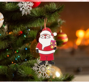 Close-up of a wooden Santa Claus ornament hanging on a festive tree with glowing lights