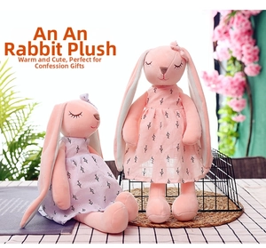 Close-up of cute pink plush bunny dolls in floral dresses with soft embroidery details
