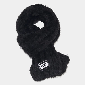 Détail d'une écharpe en fausse fourrure noire avec écusson blanc à lettres LOVE