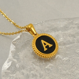 Gold stainless steel initial A necklace with black enamel pendant and beaded border
