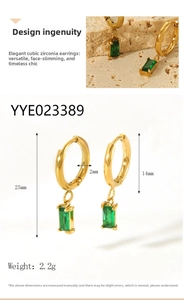 Détails macro de créoles plaquées or 18 carats avec pendentifs en zircon vert et tailles
