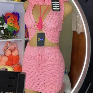 Detailed close-up of pink handmade crochet bikini set featuring butterfly halter top and skirt