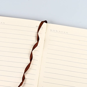 A5 faux leather notebook with ruled pages and a brown ribbon bookmark for office use