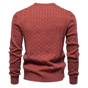 Detailed back view of a brick red cable knit sweater featuring classic knitted textures