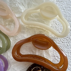 Variety of glossy jelly-colored hollow hair claws in various shades on white background