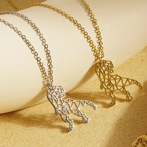 Detail of gold and silver dinosaur pendants with modern geometric cutout design