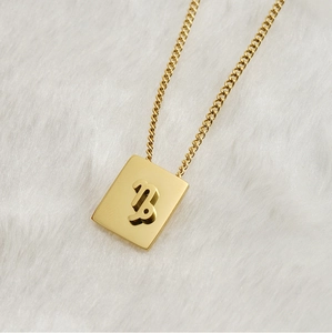 Dettaglio della collana con ciondolo quadrato Capricorno in acciaio dorato 18K su pelliccia