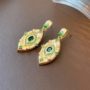 Vintage gold drop earrings with oval green gemstone and radiating textured finish