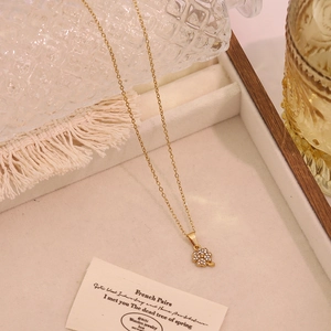 Elegante goldene Kleeblatt-Halskette mit funkelnden Kristallen in einer Schmuckschatulle