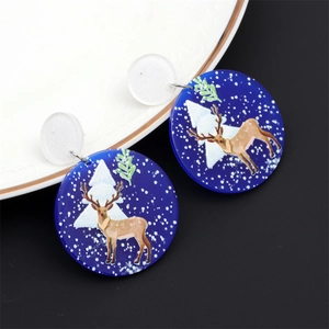Détail de boucles d'oreilles de Noël en acrylique avec motif renne sur plat céramique
