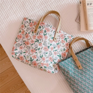 Detail of quilted floral tote bags featuring vintage cotton fabric and leather handles