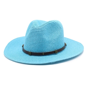 Detail of light blue straw jazz hat featuring a vintage brown faux leather band with metal studs