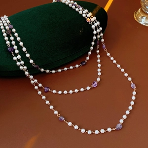 Detailed shot of white pearls and purple amethyst beads on a vintage gold chain