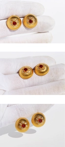 Macro detail of French retro gold disc earrings with red zircon and sunburst pattern