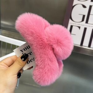 Close-up of fluffy pink faux fur hair claw clip showing soft texture and metal spring