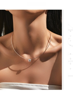 Sparkling silver flower necklace with central crystal worn on neck under artistic shadows