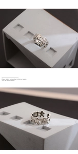 Macro detail of vintage silver open ring with gingerbread man and moon motifs