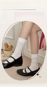 Detail of white crew socks with heart embroidery and wavy edge in ballet style