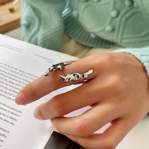 Minimalist silver liquid metal style irregular open ring on a model holding a book