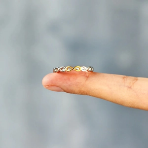 Detail of s925 silver infinity ring with two-tone gold and silver finish on finger