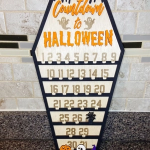 Wooden Halloween countdown calendar sign with numbers 1 to 31 on a tiled countertop