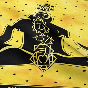 Macro detail of high-contrast chakra symbols and stars on yellow bohemian tapestry