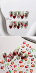 Vue macro d'autocollants fraise pour ongles avec dorure 3D et détails de fleurs gaufrées