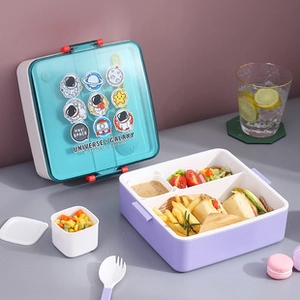 Close-up of a purple 4-compartment lunch box with blue space-themed lid and cutlery
